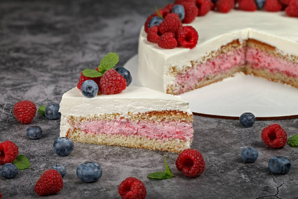 Delicious raspberry cake with cream and decorated with fresh raspberry berries and mint leaves - Zdjęcie, obraz
