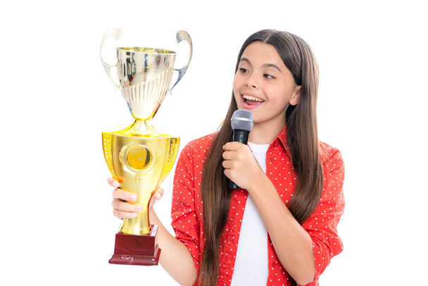 Kazanan kupasıyla genç bir kız. Elinde ödül mikrofonu olan bir genç. Kazanan çocuk yarışmayı kazandı, başarıyı ve zaferi kutladı. - Fotoğraf, Görsel