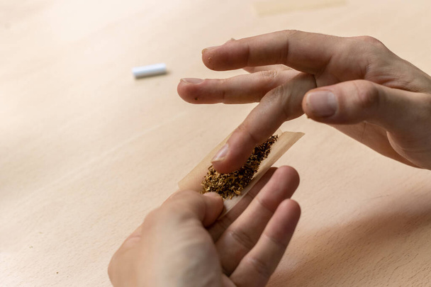 A close-up of a man's hands preparing marihuana joint - Foto, afbeelding