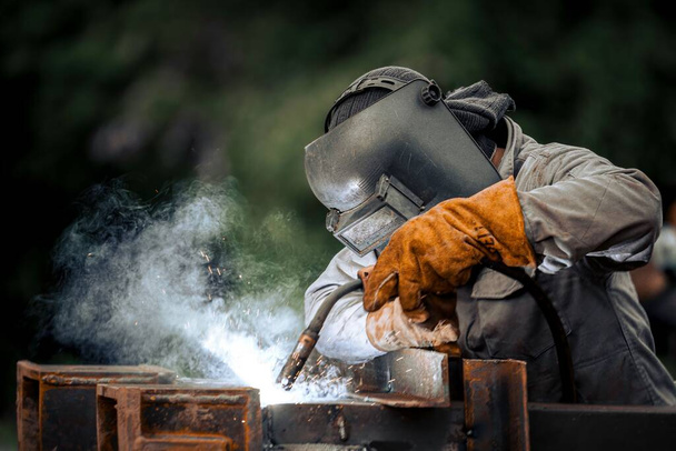 A man in a protective mask welding metal construction - Foto, Imagem