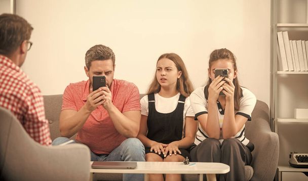 phone addicted father mother and child at family psychologist, addiction. - 写真・画像