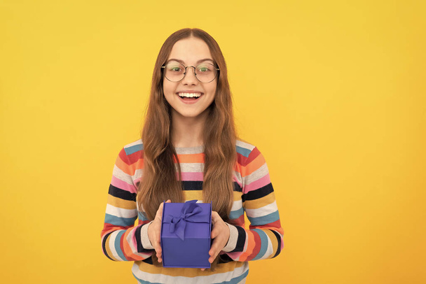happy birthday holiday. black friday discount. seasonal sales. cheerful teen girl in eyeglasses with box. boxing day. present and gifts buy. shopping child with purchase. kid with box. - Foto, imagen