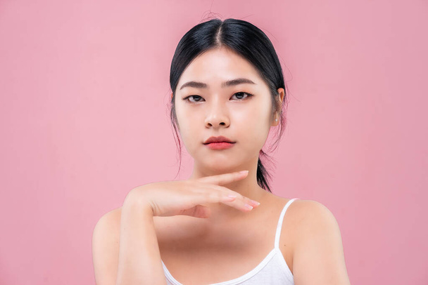 Close up Beauty shot of Beautiful Asian girl looking at camera isolated on pink background. - Photo, image