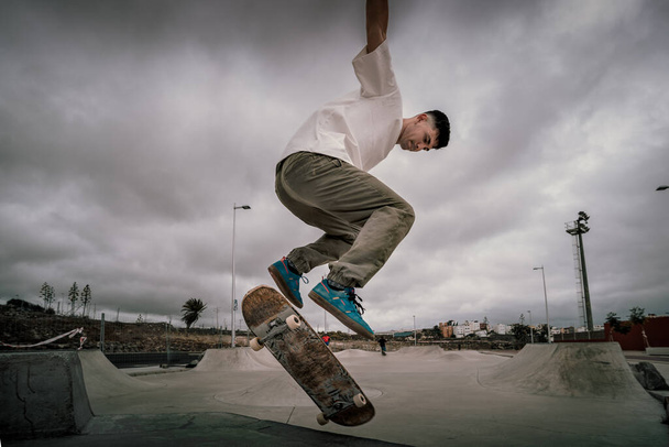 young man jump over a ramp in a skate park - Fotó, kép