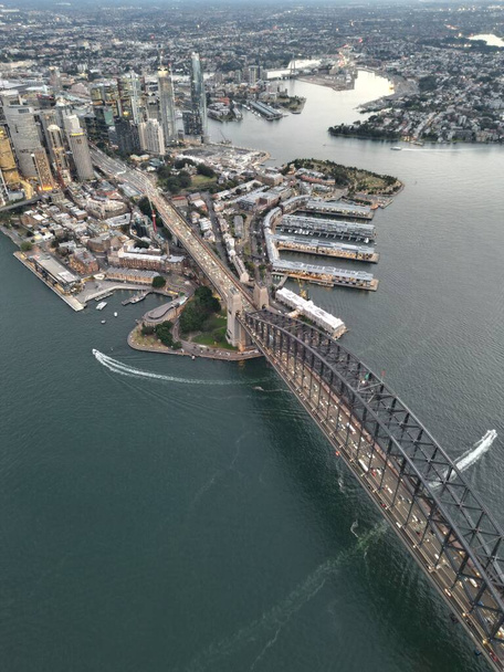 A vertical aerial view of the Sydney harbor bridge and a surrounding cityscape - Фото, зображення