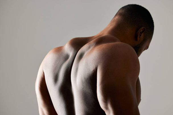 The real workout starts when you want to stop. Studio shot of a unrecognizable male flexing his back muscles against a grey background - Fotó, kép