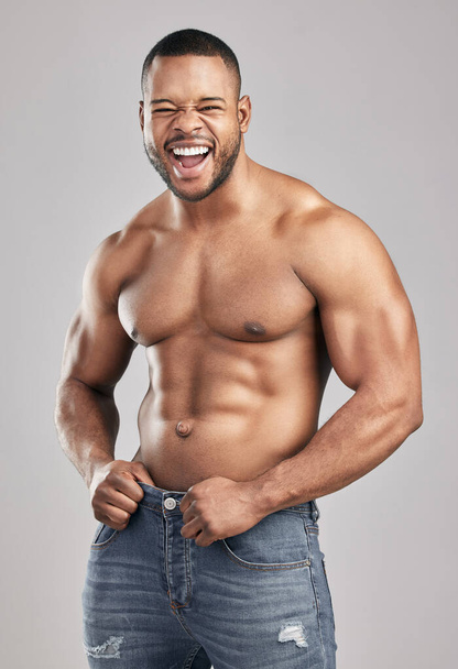 Stimulate dont annihilate. Studio shot of a young muscular man posing against a grey background - Фото, зображення