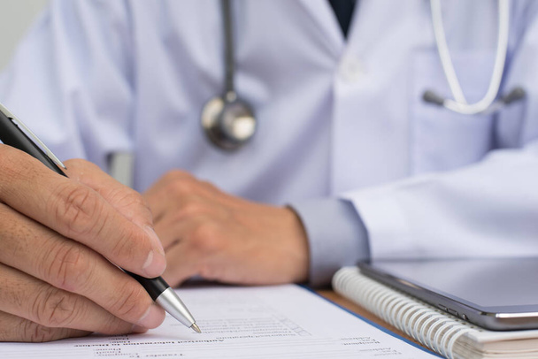 Male doctor writing health checklist or patient's history, close up. - Φωτογραφία, εικόνα