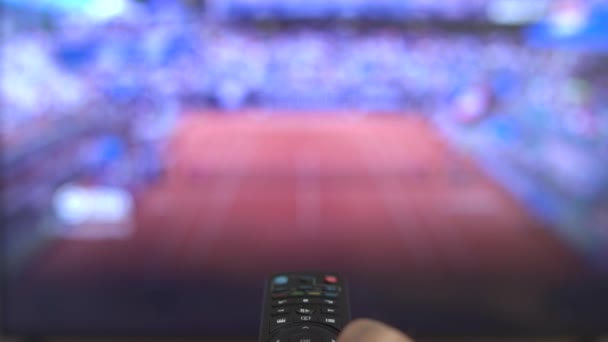 sports fan changing channels on tv watching remote control close up. High quality 4k footage - 映像、動画