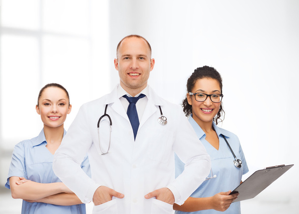 group of smiling doctors with clipboard - Foto, Bild