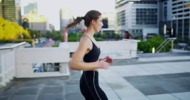 4k video footage of an attractive young woman checking the time while out jogging in the city. - Кадри, відео