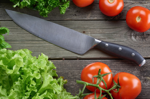Kitchen knife in table with vegetables - Foto, afbeelding