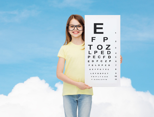 little girl in eyeglasses with eye checking chart - Фото, зображення