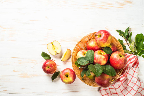Appels. Verse rijpe rode appels in de mand aan witte tafel. Bovenaanzicht. - Foto, afbeelding