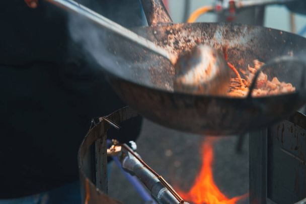 Asya 'da yerel bir tezgahta kızarmış kue teow noodle pişirirken çekilmiş bulanık bir fotoğraf.. - Fotoğraf, Görsel
