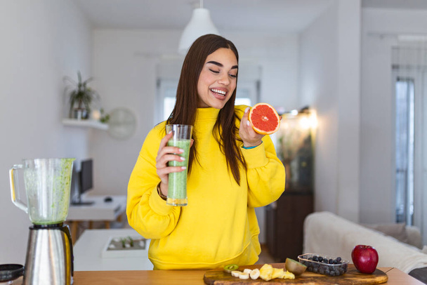 Beautiful woman holding glass of smoothie. Holding grapefruit. Healthy lifestyle. Raw food diet, vegetarian nutrition, organic detox meal - Photo, image