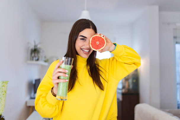 Beautiful woman holding glass of smoothie and grapefruit. Healthy lifestyle. Raw food diet, vegetarian nutrition, organic detox meal - Photo, Image