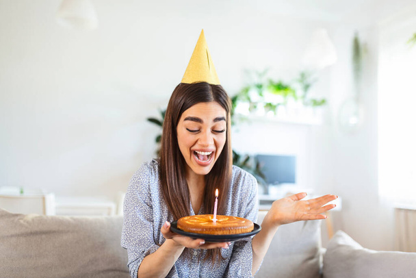 Kopieer ruimte opname van een vrolijke jonge vrouw die een verjaardagsfeest viert met een vriend over een videogesprek. Ze maakt een feestelijke toast met een glas witte wijn richting laptop camera. - Foto, afbeelding