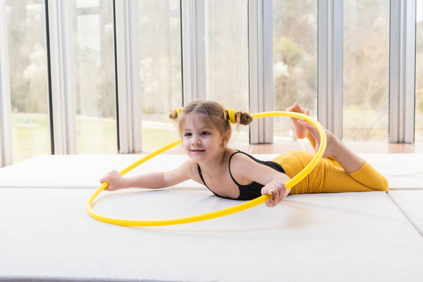 Little blonde girl with piggy tails playing with hula hoop - Foto, immagini