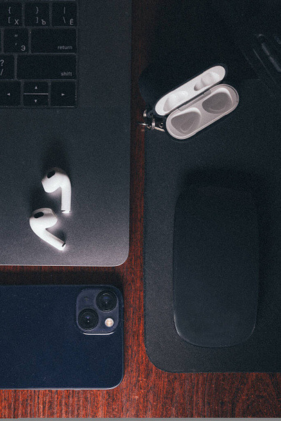 Overhead shot of dark workplacewith a laptop, smartphone and wireless headphones. - Photo, Image