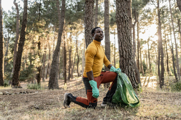 African man, altruistic volunteer who collects garbage from the forest to protect the environment. - Valokuva, kuva