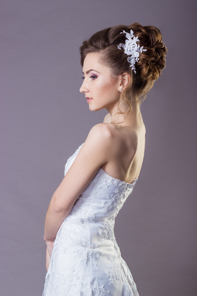 Portrait of a beautiful gentle and elegant girl women bride in a white dress with a beautiful hairstyle and makeup - Valokuva, kuva