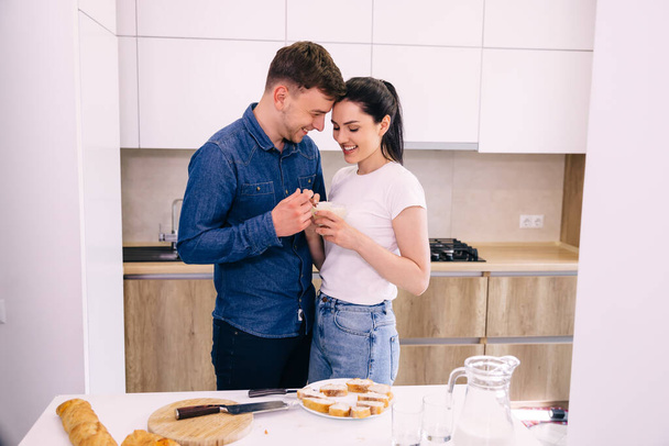 glückliches Paar beim gemeinsamen Frühstück in der Küche. - Foto, Bild