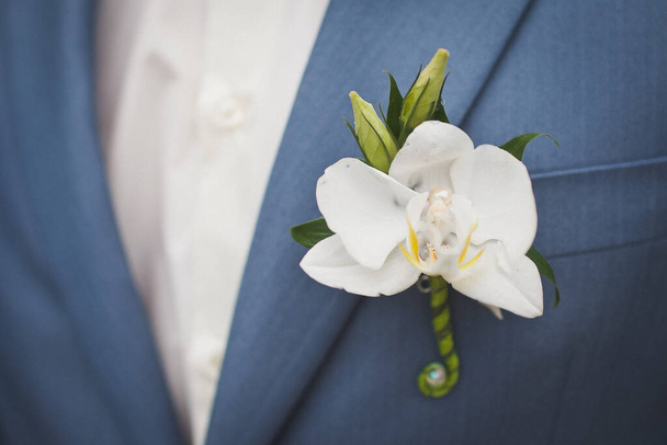 Κομψό γαμήλιο μπουτονιέρα στο κοστούμι του γαμπρού. - Φωτογραφία, εικόνα