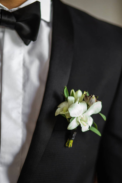 Elegant wedding boutonniere on the groom's suit. - Zdjęcie, obraz