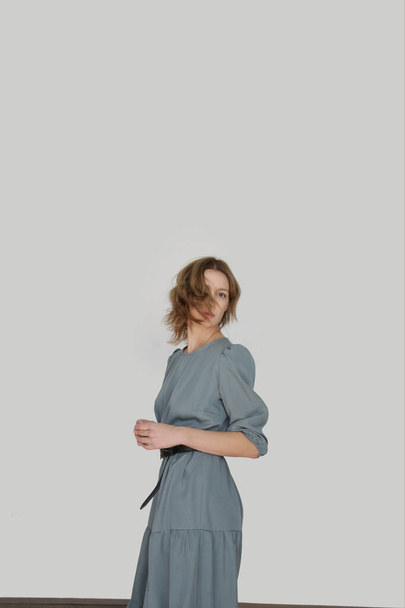 Serie of studio photos of young female model in casual gentle grey midi dress - Φωτογραφία, εικόνα