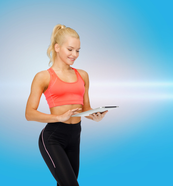 smiling sporty woman with tablet pc computer - Valokuva, kuva