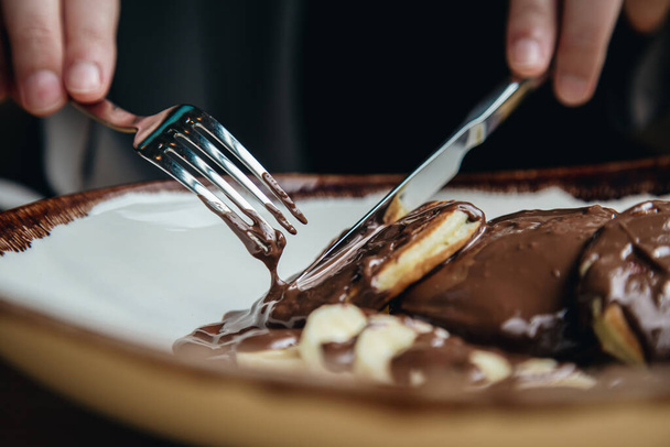 Close-up, heerlijke pannenkoeken met warme chocolademelk en banaan als ontbijt. - Foto, afbeelding