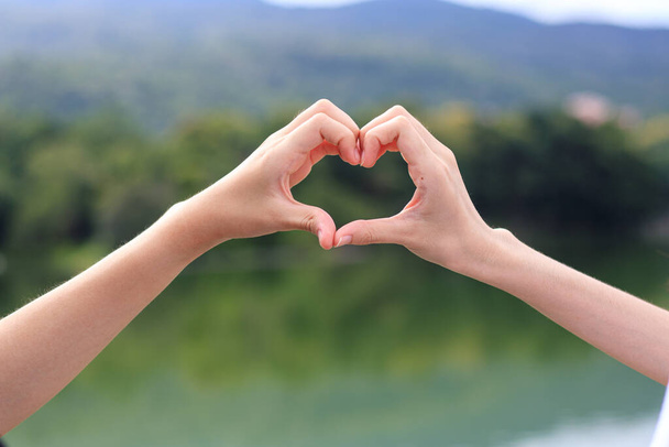 A young LGBTQ couple use both of their hands to show a heart symbol together in an effort to communicate the understanding and acceptance of the love of LGBTQ people.Copy Space for text - Photo, image