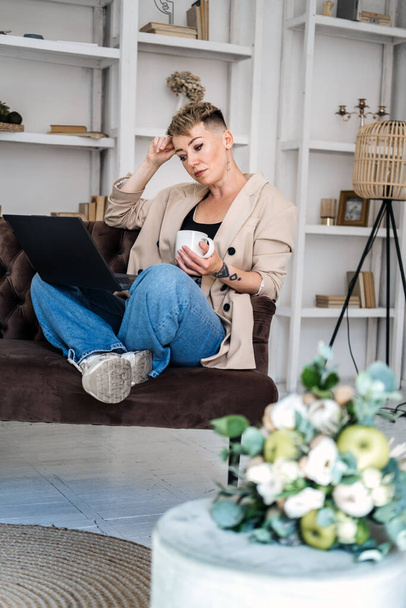 Start Own Business. Young trendy woman planning new project with papers and laptop in home office. Hipster woman florist working on their own business at home. - 写真・画像