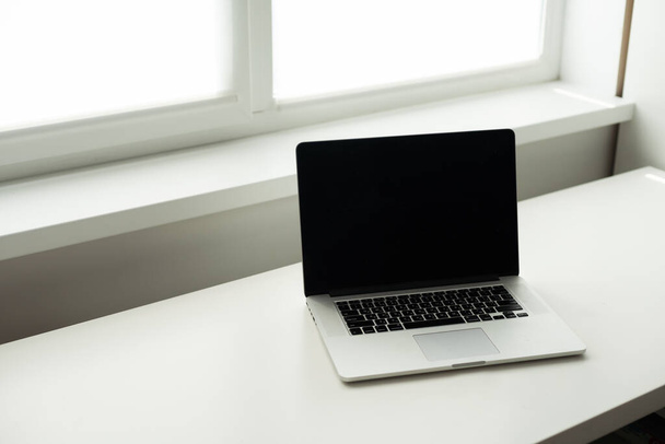 Horizontal photo of minimal workplace with computer laptop on white desk - Fotografie, Obrázek