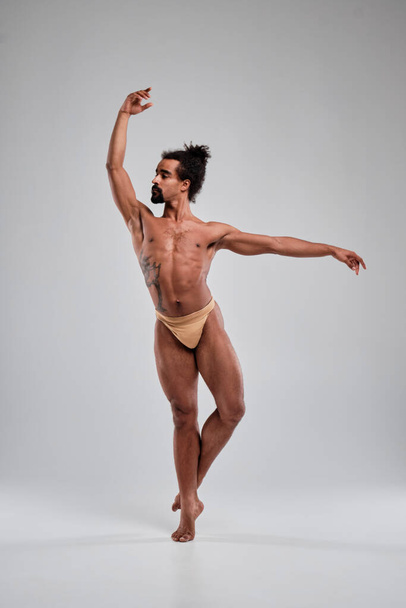 Handsome black guy dancing topless on a white background. - Valokuva, kuva