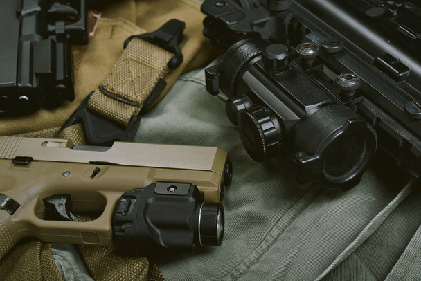 Waffen und militärische Ausrüstung für Armee, Sturmgewehr (M4A1) und Handfeuerwaffe 9mm auf grünem khakifarbenem Hintergrund. - Foto, Bild
