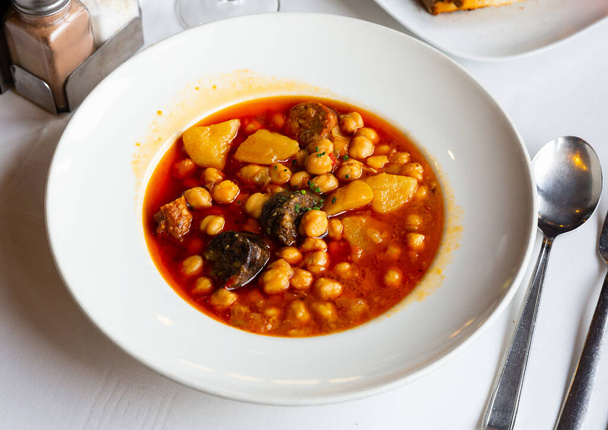 Garbanzos del pastor, spicy soup with chickpea, vegetables and sausages served in a restaurant - Фото, зображення