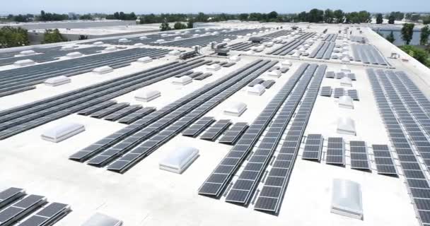 4k Pan antenne van zonnepanelen gemonteerd op het dak van grote industriële gebouw of magazijn. - Video
