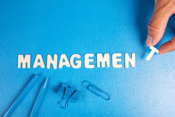 Management concept. Tekst uit witte houten letters op een blauwe achtergrond. - Foto, afbeelding