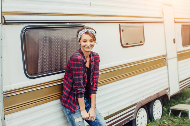 Beautiful girl with backpack traveling. Girl standing near trailer traveling in mountains. Woman in glasses traveling by car. Traveler. Girl thumbs up. - Photo, Image
