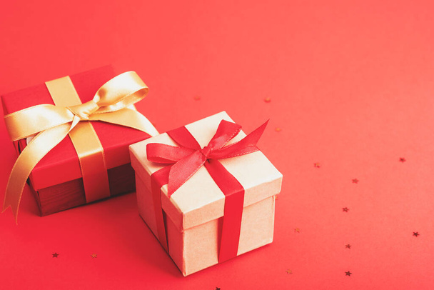 Two gifts boxes on red background, top view. New Year, Christmas concept. - Фото, зображення