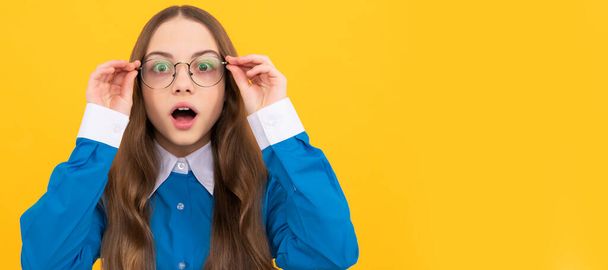 Shocked school aged girl child in spectacles with amazed look yellow background, amazement. Child face, horizontal poster, teenager girl isolated portrait, banner with copy space - Φωτογραφία, εικόνα