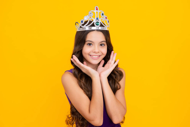 Little queen wearing golden crown. Teenage girl princess holding crown tiara. Prom party, childhood concept. Happy girl face, positive and smiling emotions - Fotoğraf, Görsel