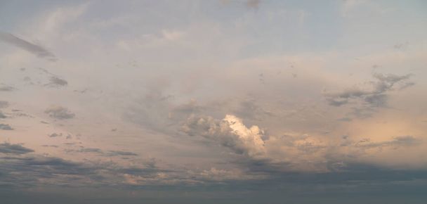 Beautiful cloudscape wide angle panorama sky replacement background with layers of colorful white, yellow, orange and blue cumulus clouds. - Fotó, kép