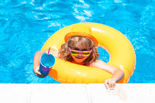 Мальчик плавает и играет в бассейне. Ребёнок играет в бассейне. Летние каникулы. Детский портрет - Фото, изображение