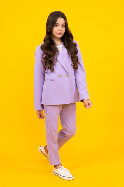 Full length of cheerful teenager child girl wearing comfy trendy fashion clothes, isolated over yellow background - Фото, зображення