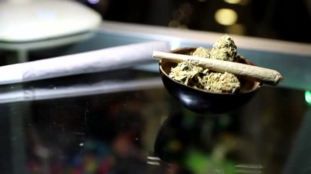 Close-up van een marihuana joint die rust op een knopje ruwe marihuana - Video