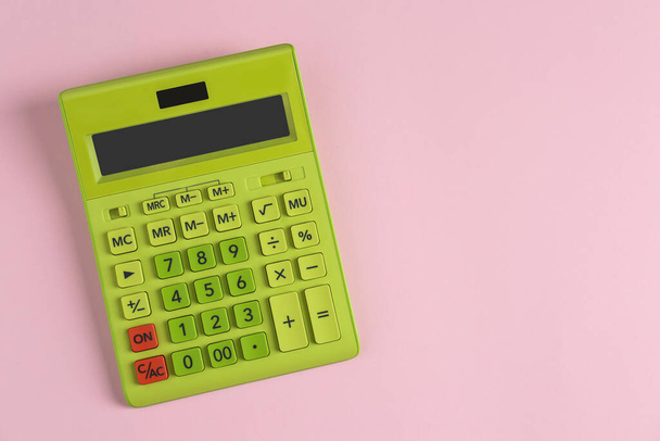 Green calculator on pink background, top view. Space for text - Foto, imagen
