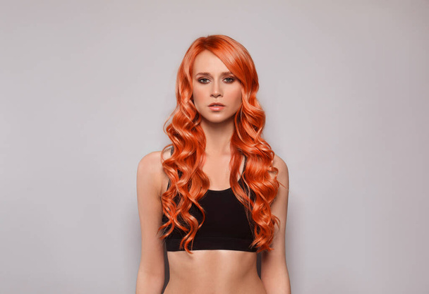 Beautiful woman with long orange hair on light grey background - Zdjęcie, obraz